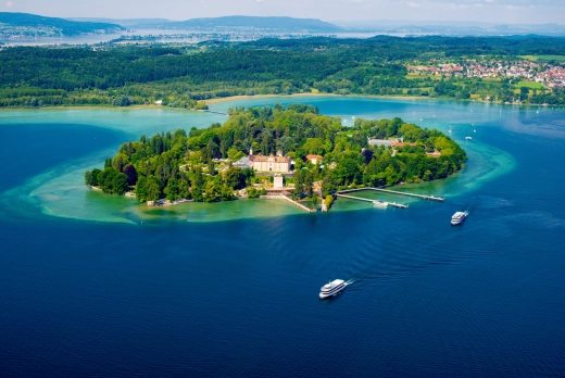 Luftaufnahme Insel Mainau im Bodensee mit Gebäuden, im blauen Wasser zwei Boote