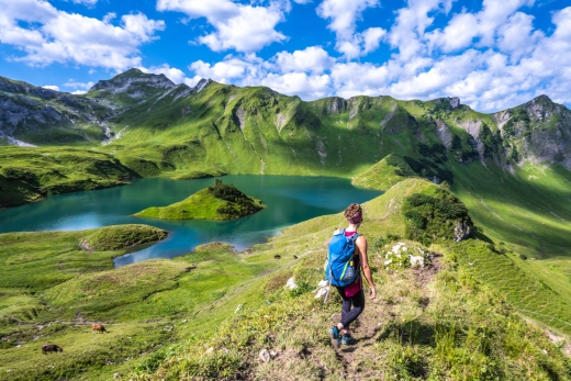 Wanderer auf einem Grat über dem Schrecksee in den Allgäuer Alpen, grüne Berghänge ringsum