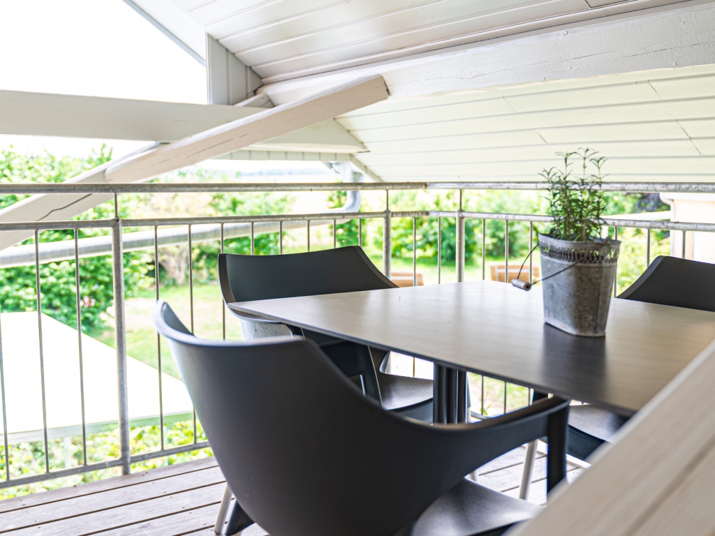 Ferienwohnung 3: Balkon mit Tisch, Stühlen und Pflanze, dahinter Blick ins Grüne