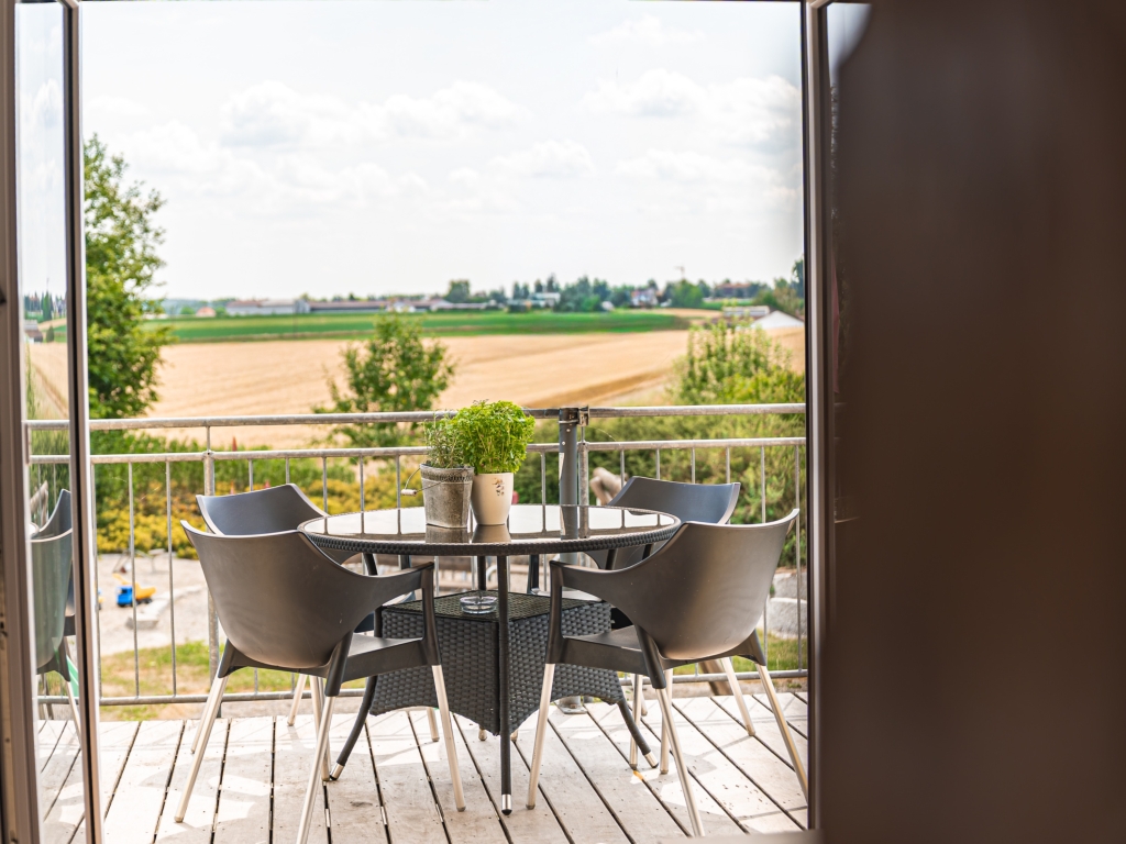 Ferienwohnung 4: Balkon mit Tisch und Stühlen und weitem Blick über Felder und Wiesen